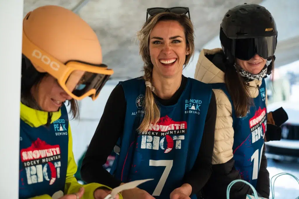 three people at a snowboarding event smile for a promotional video