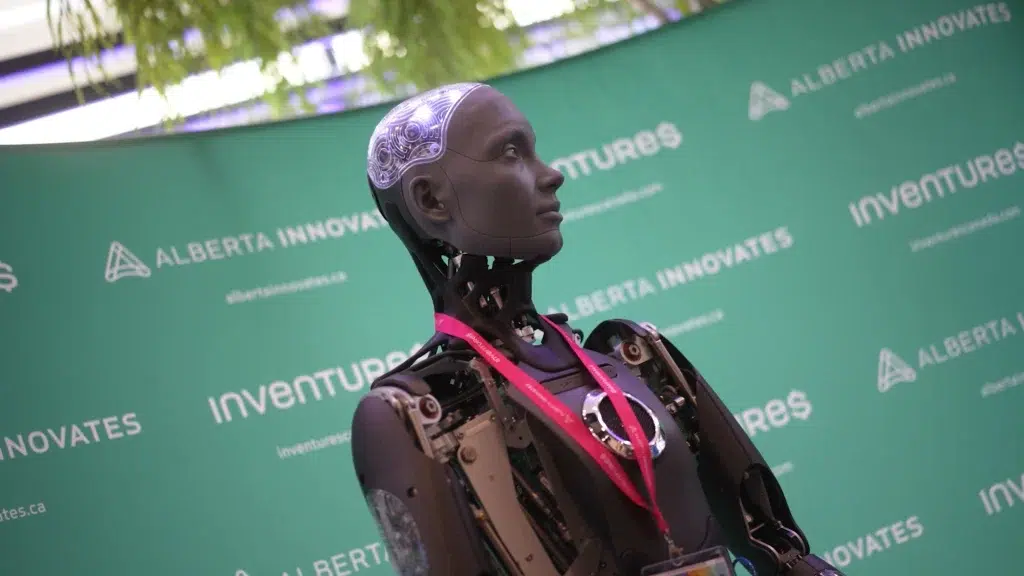 A robot in front of an innovation event banner in Alberta.