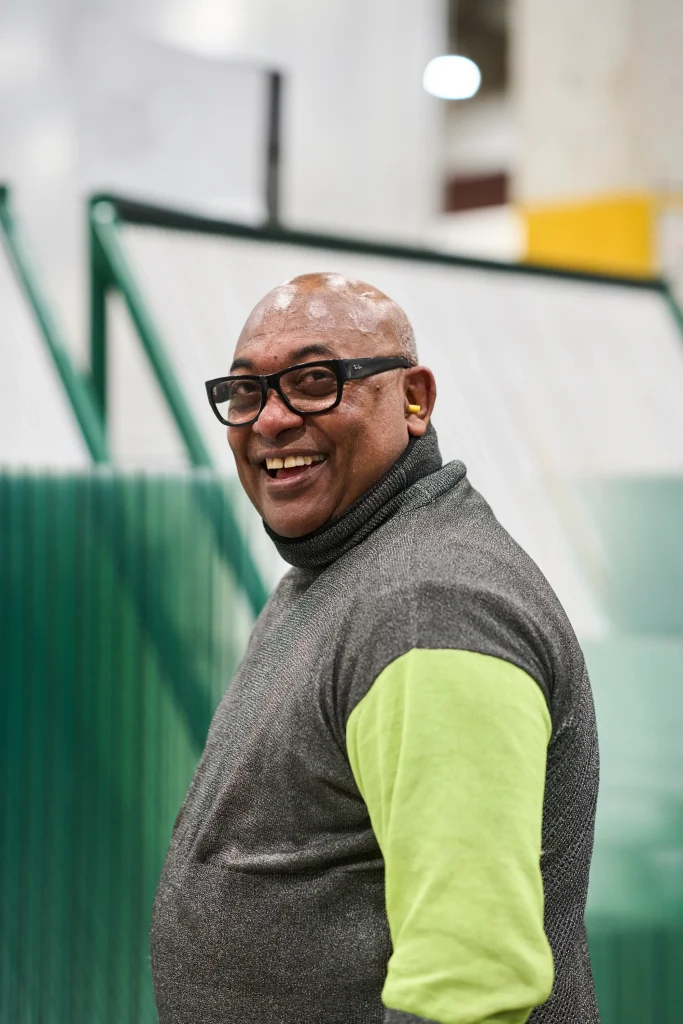A person smiles while working in a warehouse during a testimonial video in Calgary