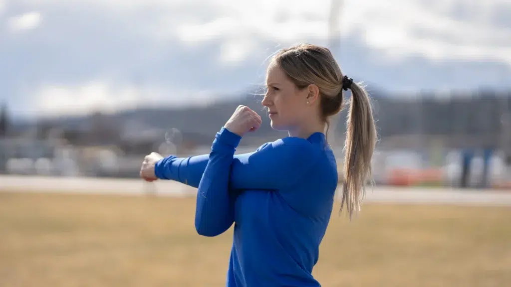 A person stretches, preparing for a demonstration within their brand video.