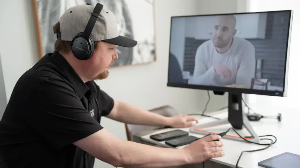 A videographer edits raw footage on a computer.