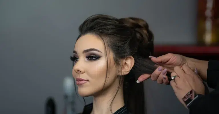 A person poses while getting their hair and makeup done during a corporate video in Calgary.