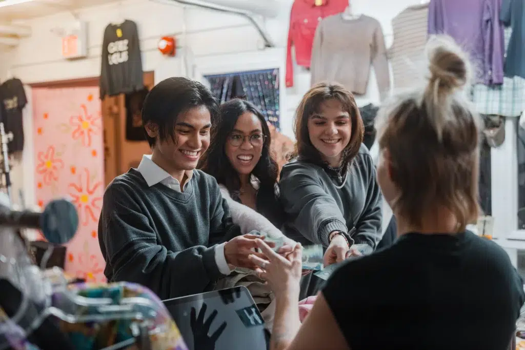 Three people pay for purchases during an ad video in Calgary.