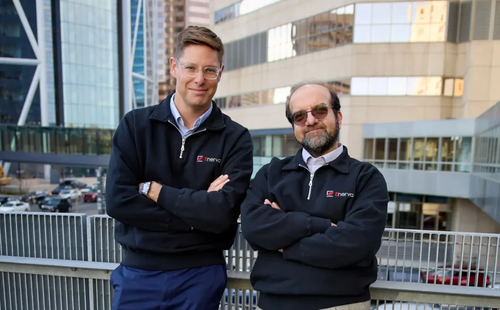 Two professionals smile and lean against a railing in downtown Calgary.
