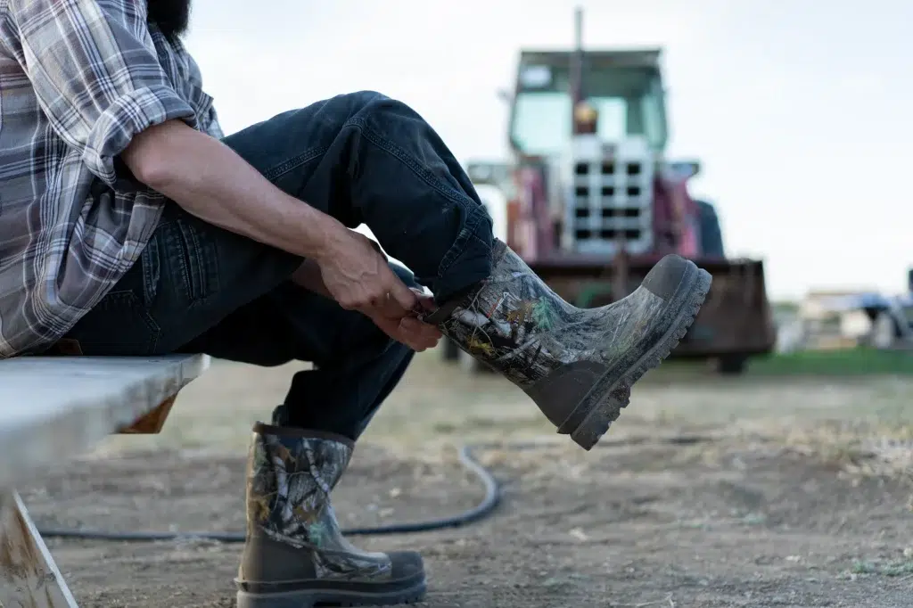 a person pulls on boots on a farm as part of a brand video for their b2b marketing strategy.