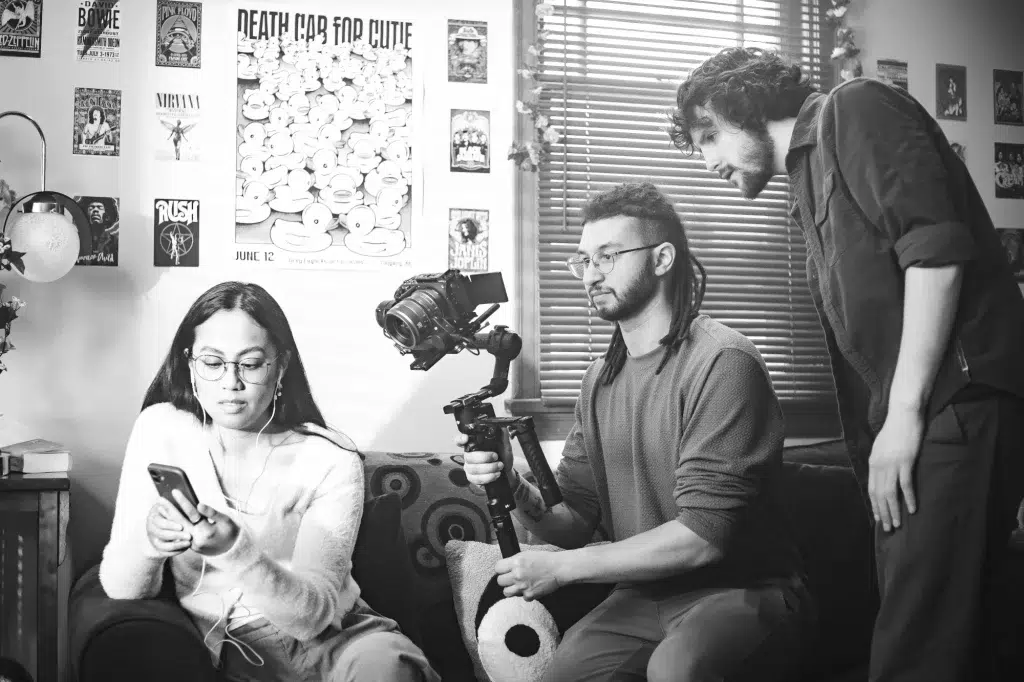 Someone looks at a video being recorded while a videographer captures a scene for a brand video.