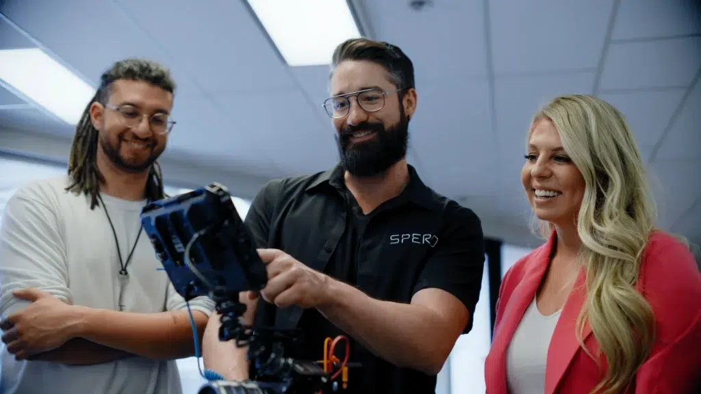 Videographers play back a scene on a video monitor for a client during a corporate video shoot.