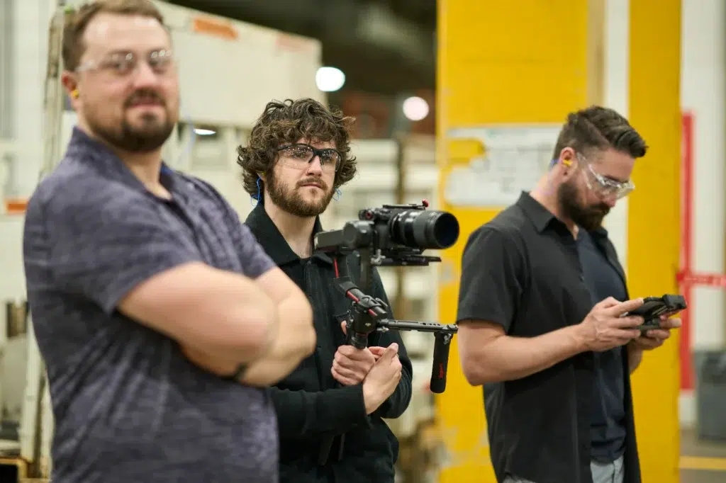 Corporate video production company captures footage for a video in a warehouse.