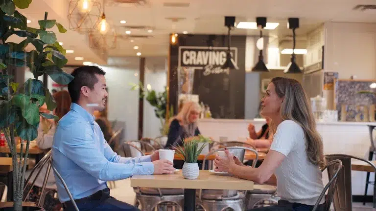 Two people share conversation over coffee at cravings bistro ad videoshoot in Calgary.